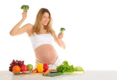 Kobieta w ciąży tańczy z warzywami